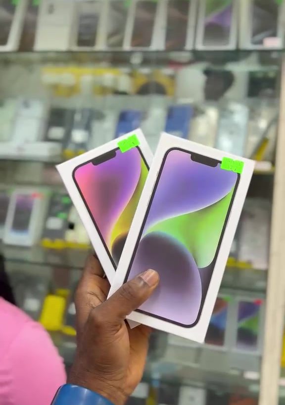 Sealed iPhone 14 128GB boxes held in hand inside Valmont Gadgets store
